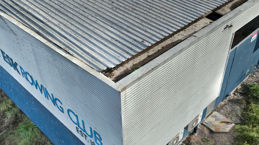 Example: close aerial view of a steel roof edge with a lifted flashing