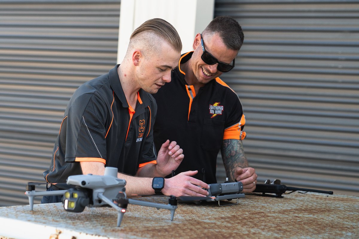 Zak and a client looking at the drone controller together beside a Matrice 4 on the ute tray