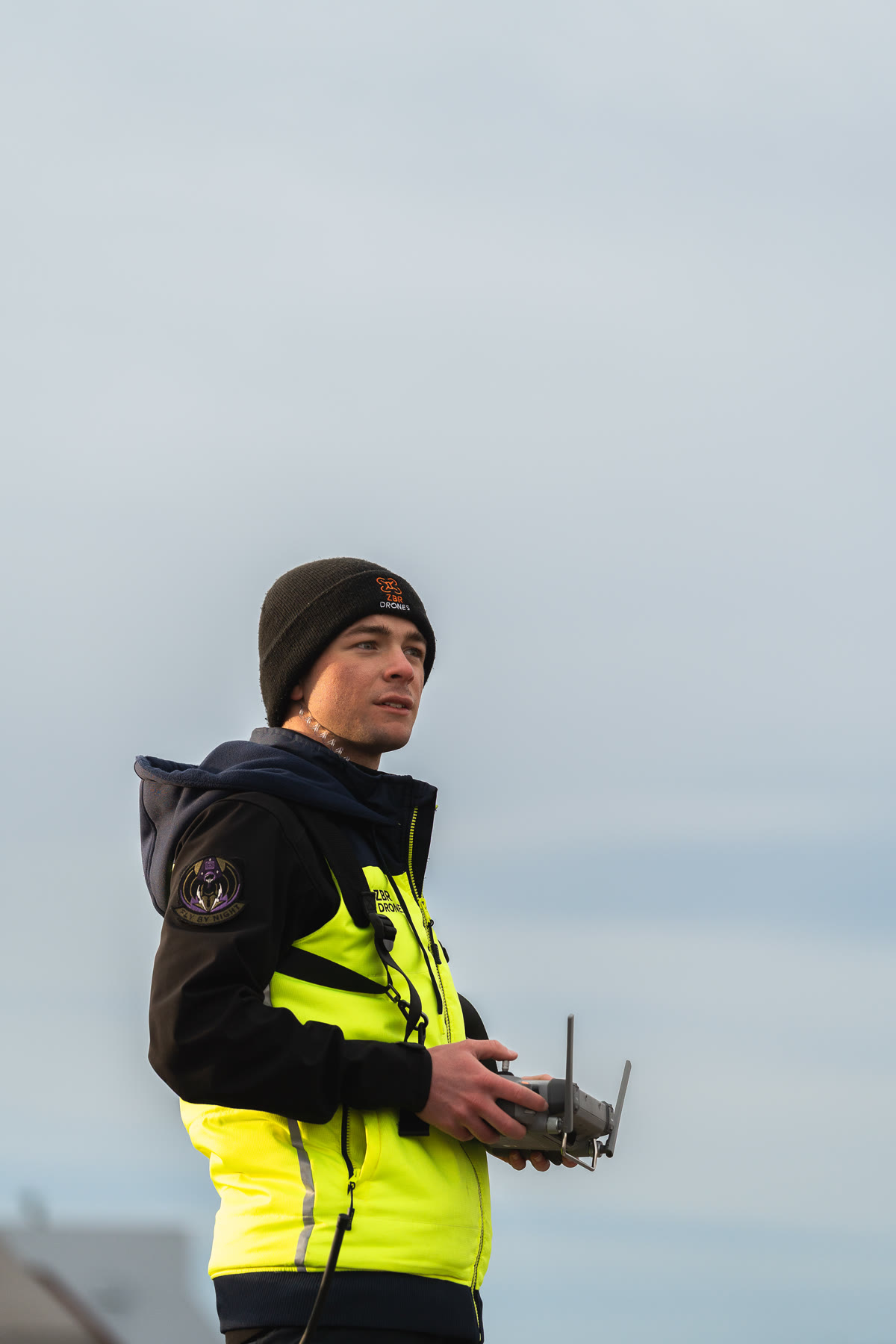Zak in hi-vis with the drone controller, looking into the distance